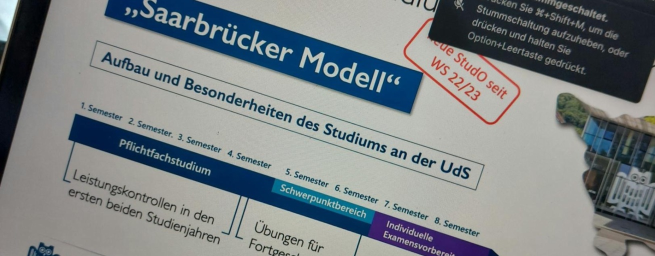 Laptopbildschirm mit geöffneter MS-Teams Veranstaltung. Gezeigt werden geteilte Folien, hier zum Jurastudium in Saarbrücken. Die konkrete Folie beschreibt den Aufbau des "Saarbrücker Modells" des Jurastudiums.