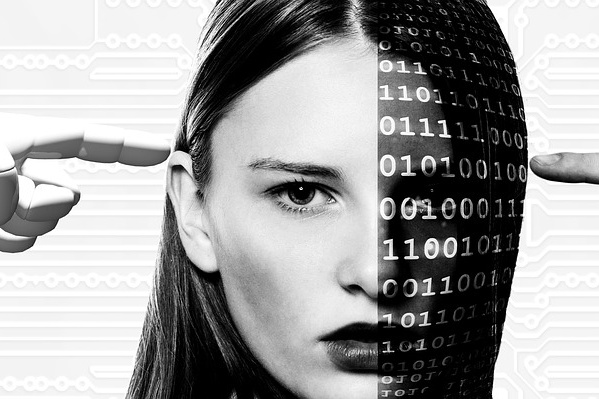 Ein Roboterarm und eine menschliche Hand zeigen auf einen weiblichen Kopf, welcher zur Hälfte mit binären Zahlen überdeckt ist.